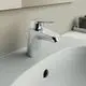 Waschtischarmatur in Chromfarbe von Ideal Standard, mit modernem Design, montiert auf einem weißen Waschtisch, neben einem Waschbecken.